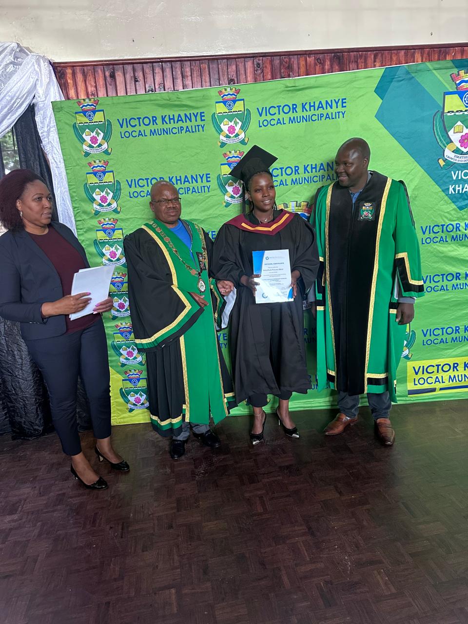 Certificate handover on stage during a graduation ceremony.